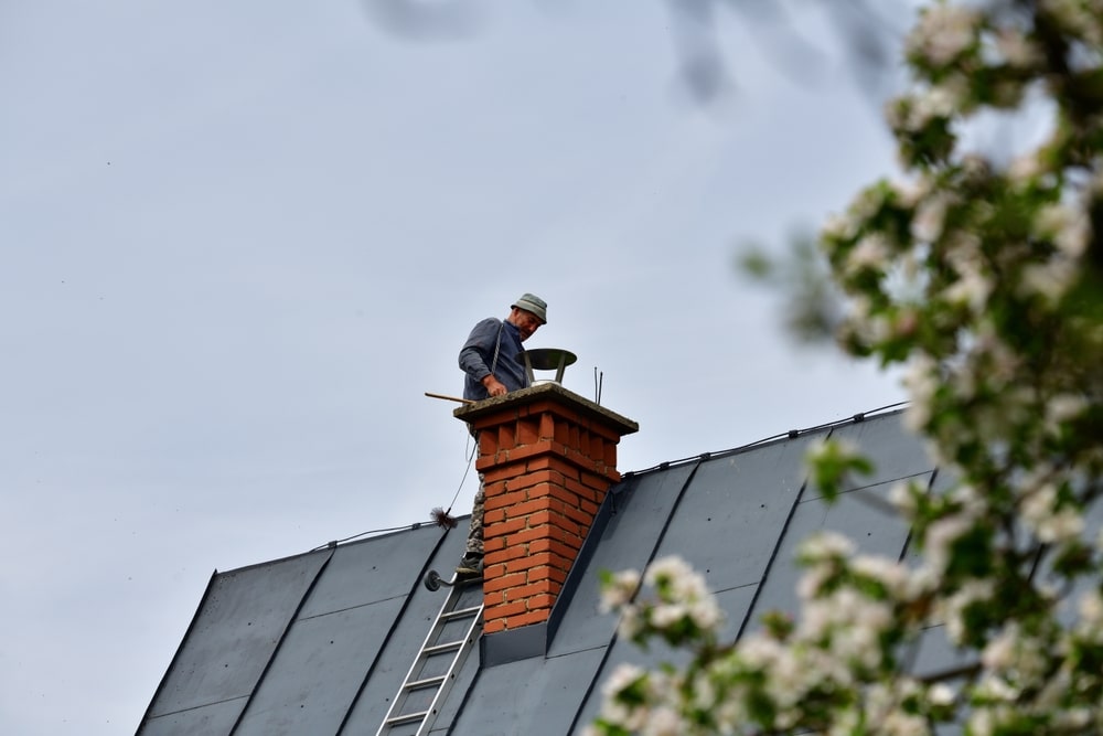 Traditional manual method of cleaning the chimney on the roof
